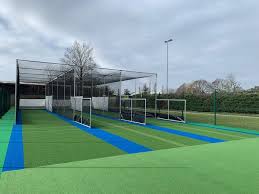 Beginner practicing batting inside a cricket net to improve skills